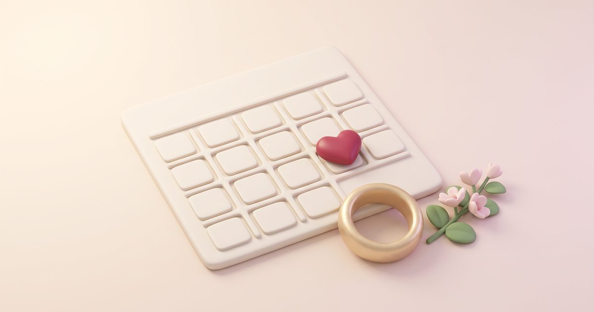 A blank calendar page with a rose heart on one day, a gold ring and a sprig of blossom