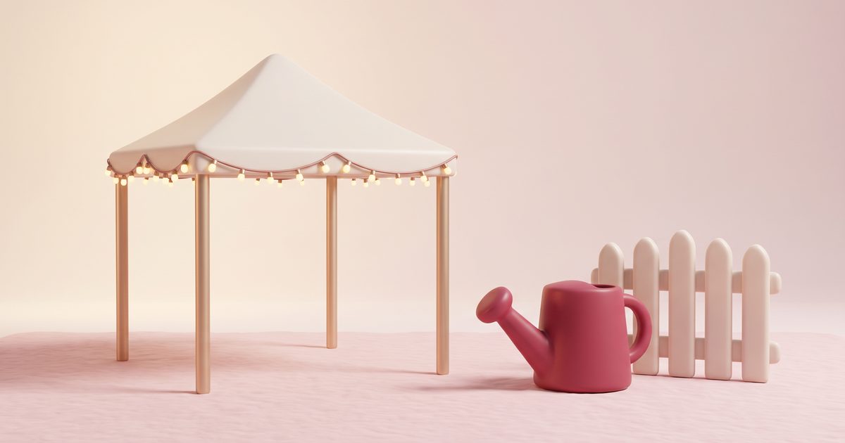 A cream garden marquee with gold poles and a string of lights, a rose watering can and a small cream gate
