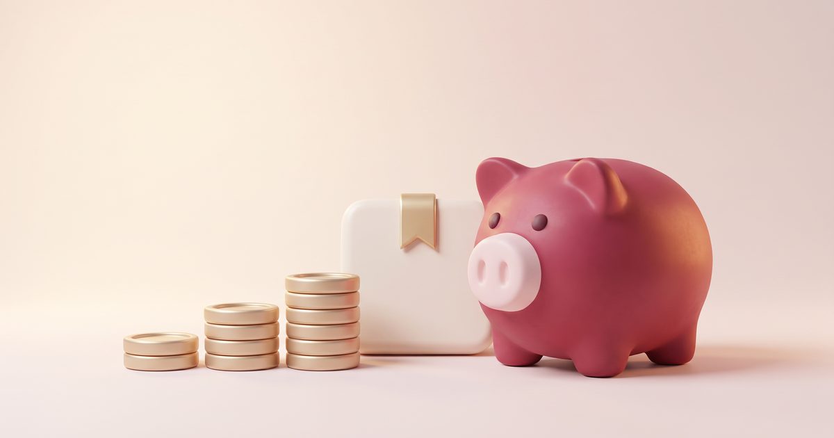 A rose piggy bank beside a cream calendar page and three rising stacks of gold coins