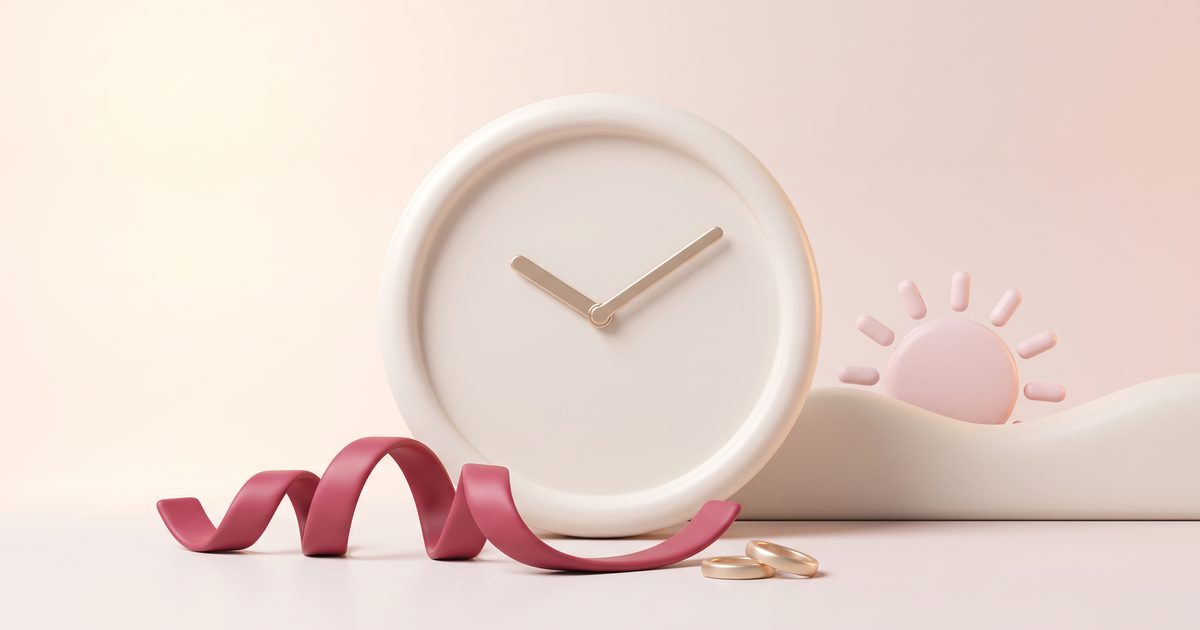 A cream clock without numbers beside a small blush sun setting behind a hill
