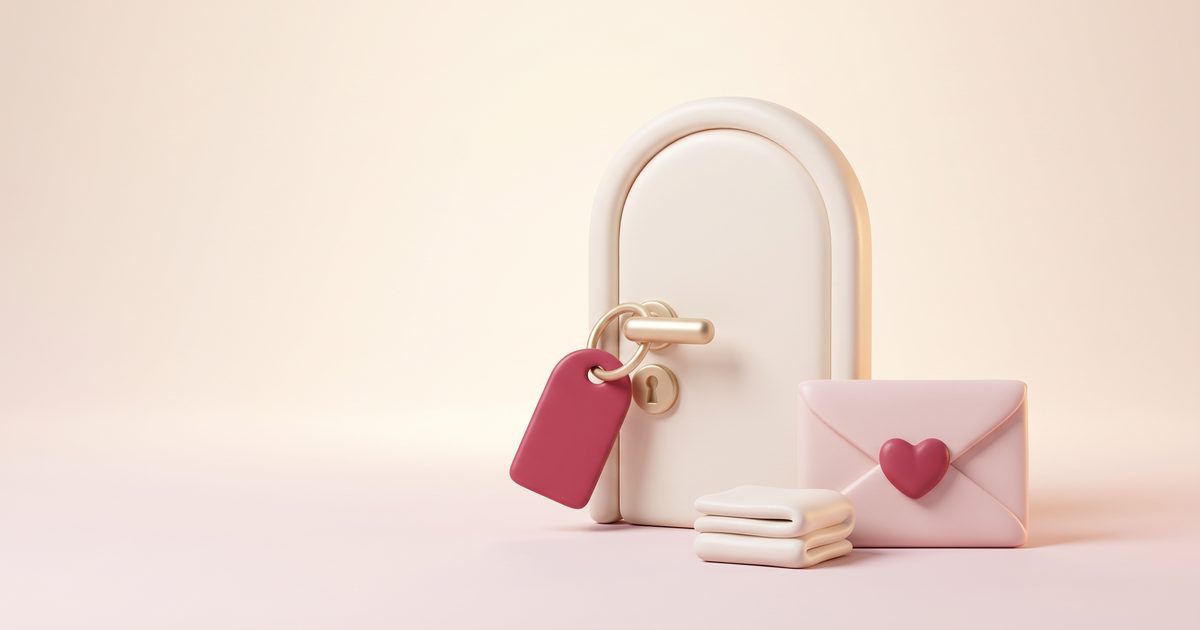 A cream clay door with a gold handle beside a rose key tag, folded towels and a sealed envelope