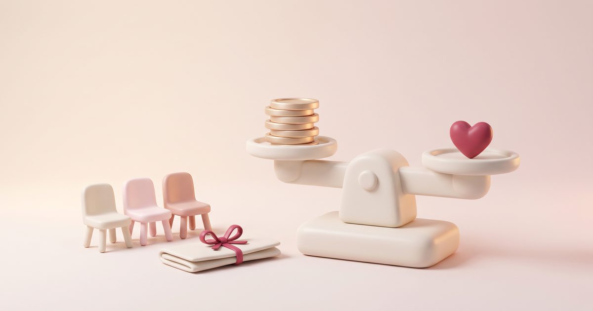 A cream scale balancing gold coins against a rose heart beside a row of small chairs