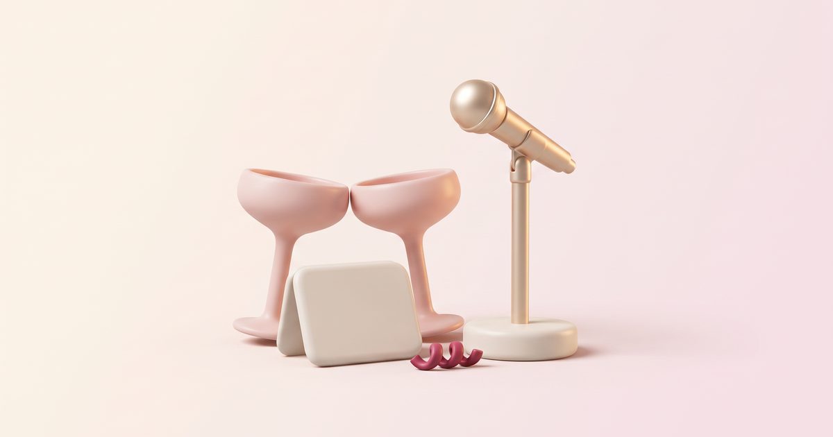 A gold microphone on a stand beside two touching blush glasses and a folded card