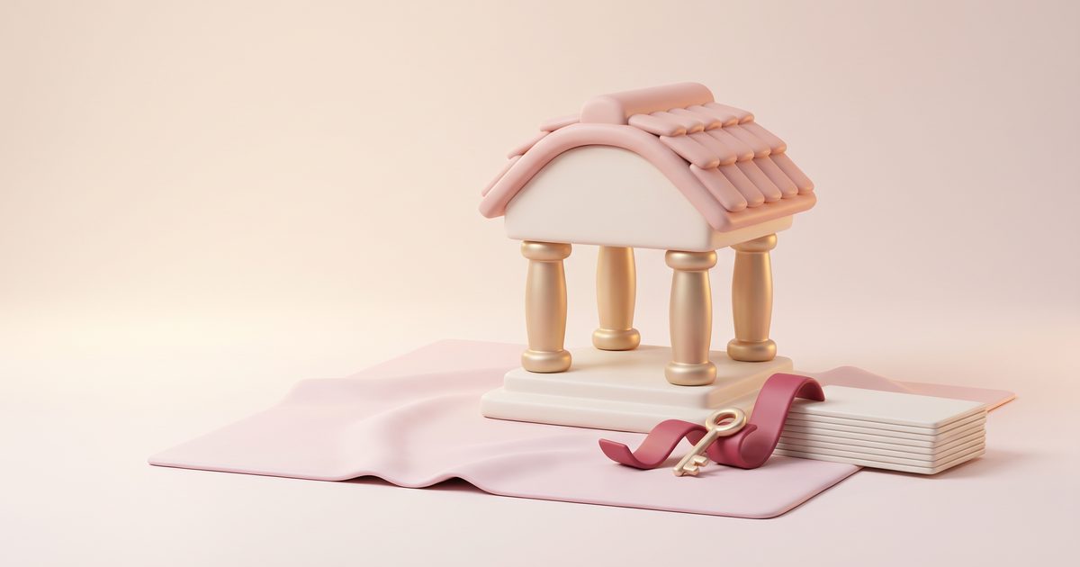 A small cream pavilion with a blush roof and gold columns beside a gold key on a rose ribbon and a few cream cards